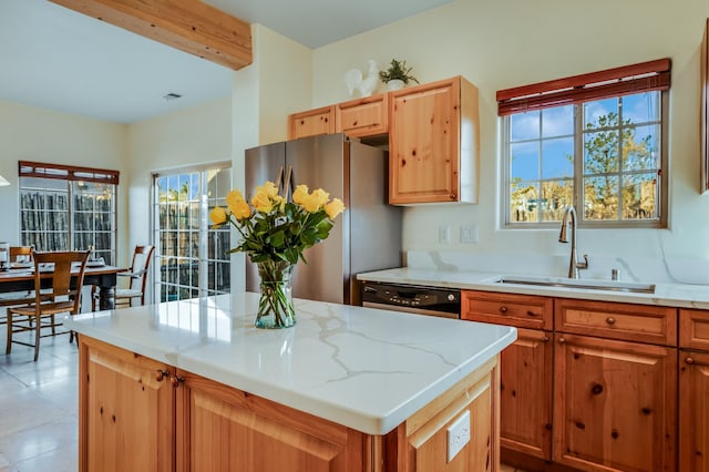 kitchen featuring stainless steel fridge, plenty of natural light, a kitchen island, and sink