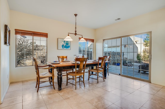 dining space featuring light tile patterned flooring and a healthy amount of sunlight