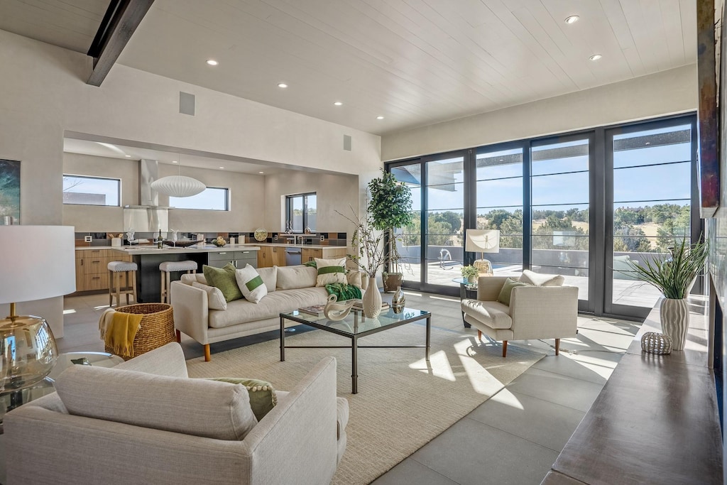 living room featuring beamed ceiling, a high ceiling, and wood ceiling