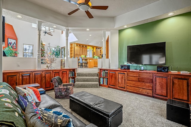 carpeted living room featuring a textured ceiling and decorative columns