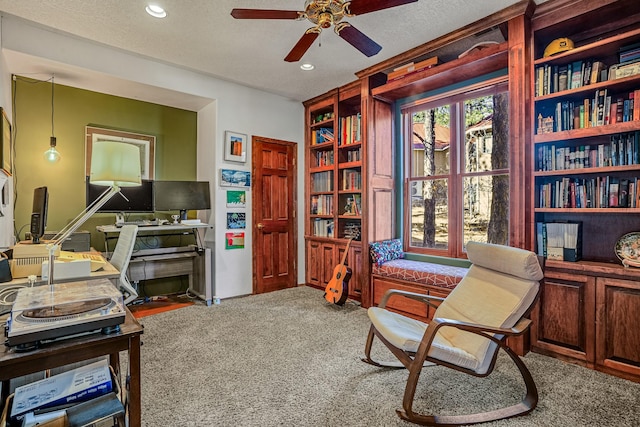 carpeted office with ceiling fan and a textured ceiling