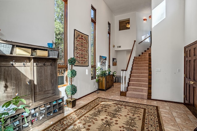 tiled entryway featuring a towering ceiling