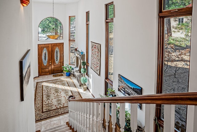 tiled entryway featuring a towering ceiling