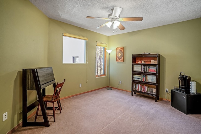 interior space with ceiling fan, light colored carpet, and a textured ceiling