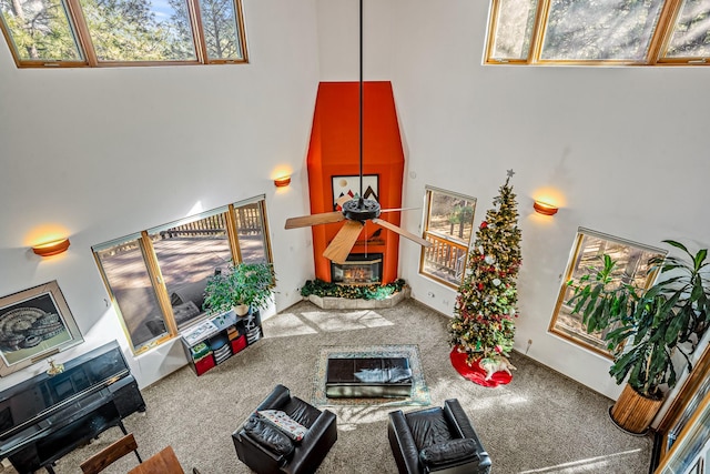 living room featuring carpet flooring, a large fireplace, and a towering ceiling