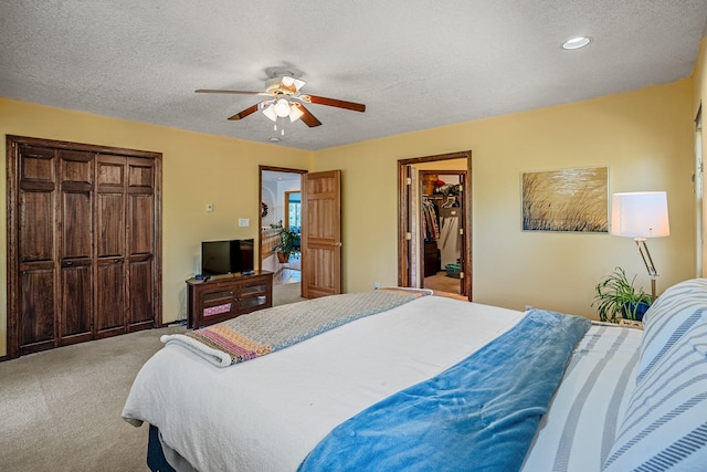 bedroom with a textured ceiling, carpet floors, and ceiling fan