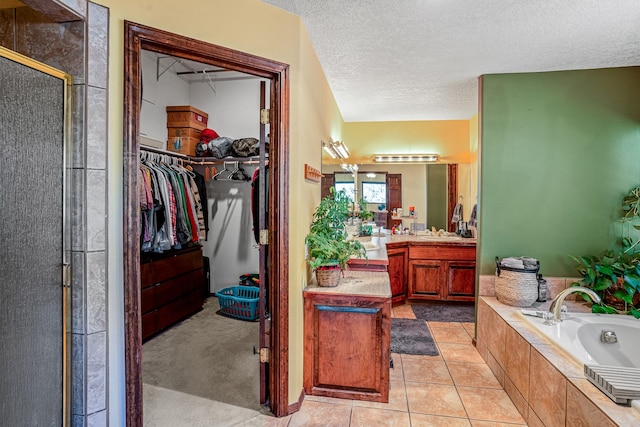 bathroom with vanity, shower with separate bathtub, a textured ceiling, and tile patterned floors