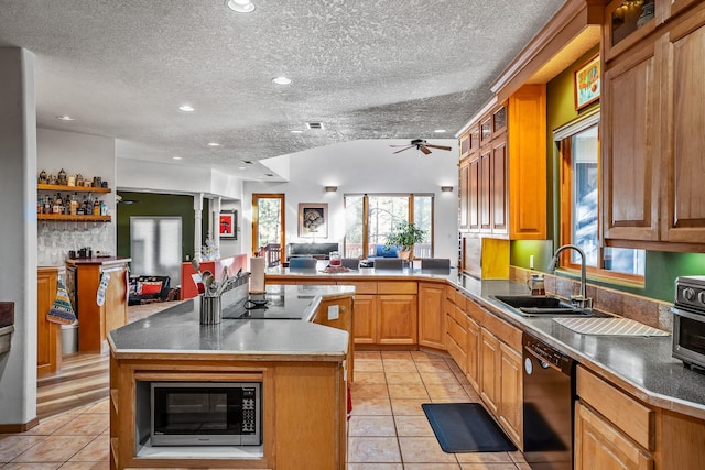 kitchen with kitchen peninsula, a textured ceiling, sink, black appliances, and a center island