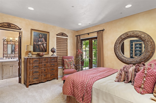 bedroom featuring french doors, sink, light carpet, and ensuite bath