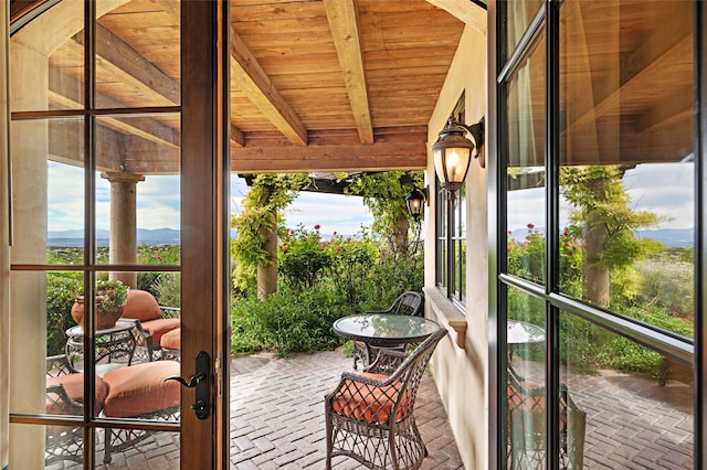 unfurnished sunroom with beam ceiling and wooden ceiling