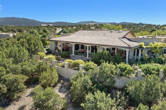 rear view of property featuring a mountain view and a patio