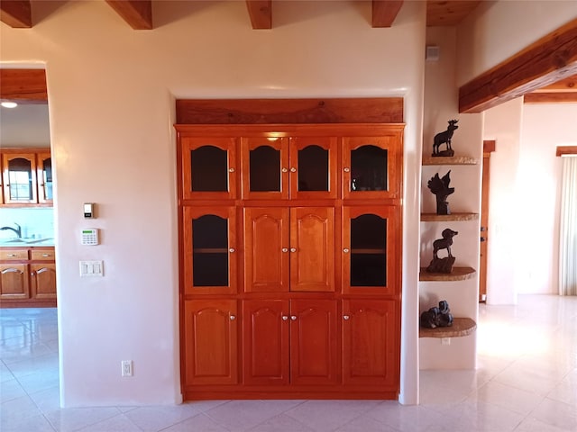 interior space featuring beam ceiling and sink