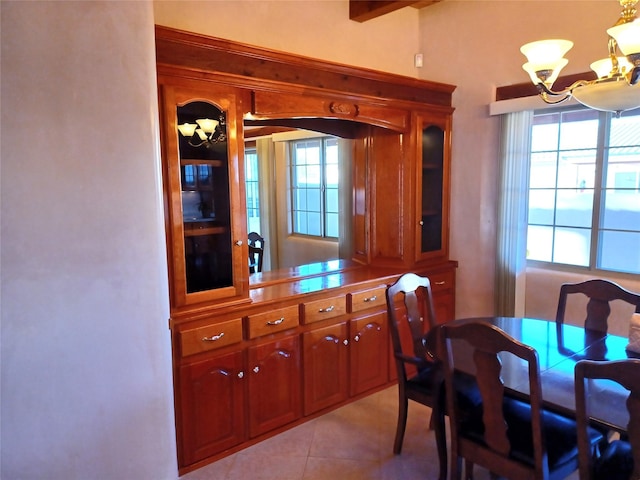 tiled dining area with beamed ceiling and a notable chandelier