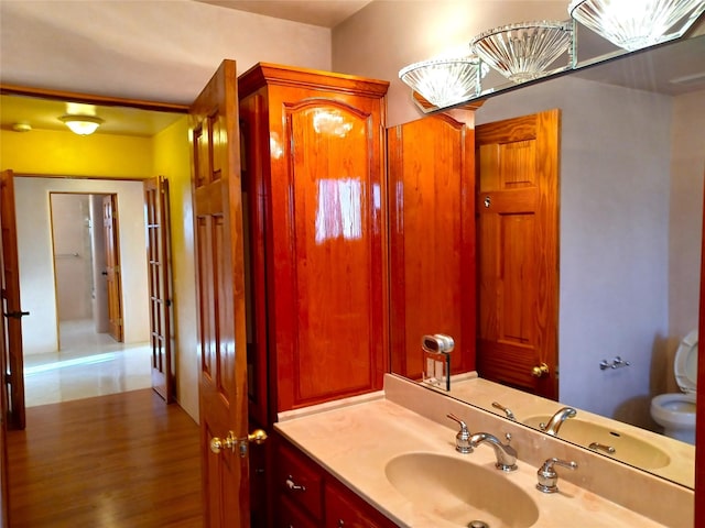 bathroom with hardwood / wood-style floors, vanity, and toilet