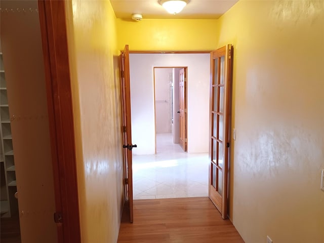 corridor featuring light hardwood / wood-style floors and french doors