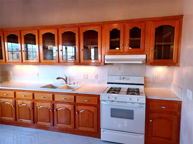 kitchen featuring light tile patterned flooring, sink, and white gas range oven