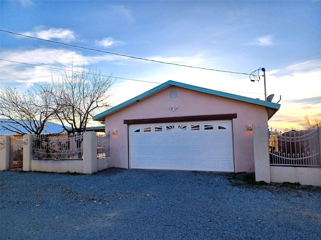 detached garage featuring a gate and fence