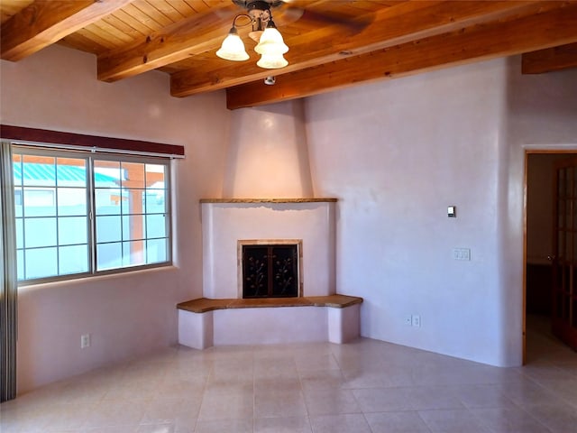 unfurnished living room with beamed ceiling, a fireplace, wood ceiling, and tile patterned floors