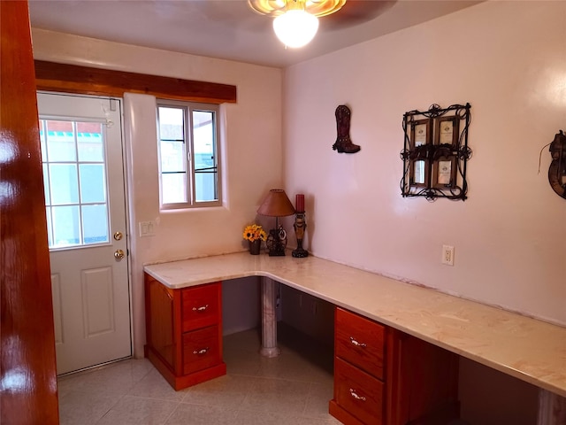 office featuring built in desk and light tile patterned flooring