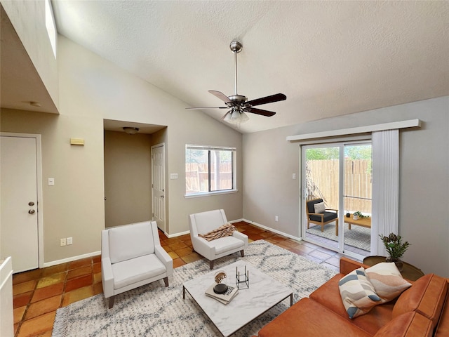 tiled living room with lofted ceiling, a textured ceiling, plenty of natural light, and ceiling fan