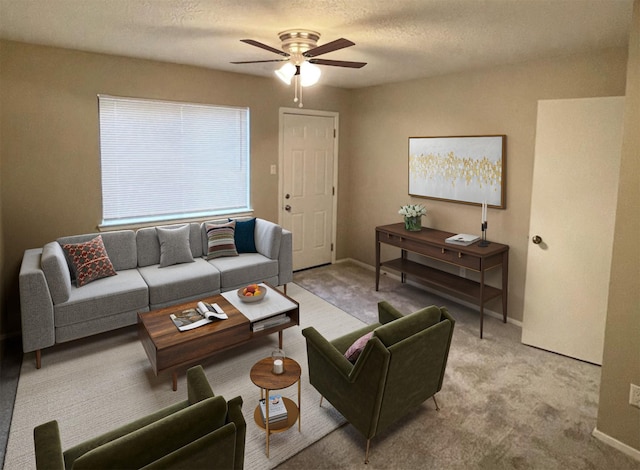 carpeted living room featuring ceiling fan and a textured ceiling