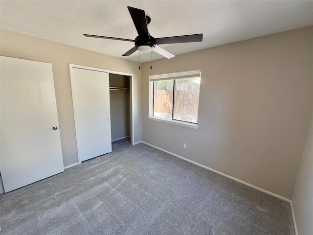 unfurnished bedroom with carpet flooring, ceiling fan, a closet, and a textured ceiling