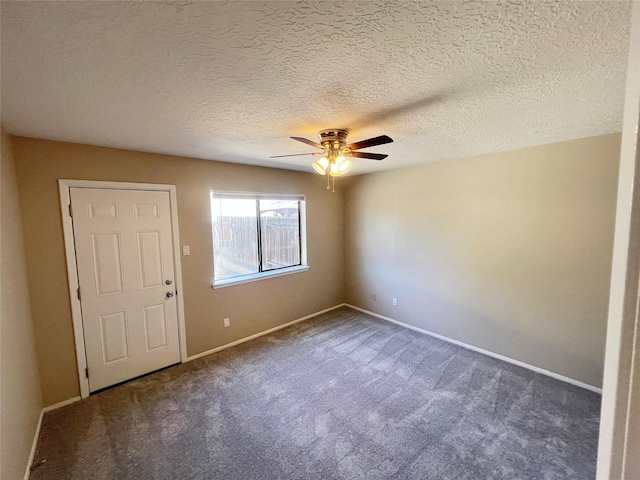 carpeted spare room with a textured ceiling and ceiling fan