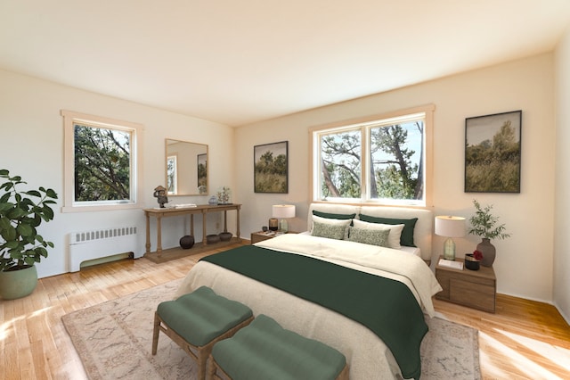 bedroom featuring radiator heating unit and light hardwood / wood-style flooring