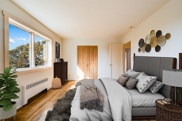 bedroom featuring light hardwood / wood-style floors and radiator heating unit