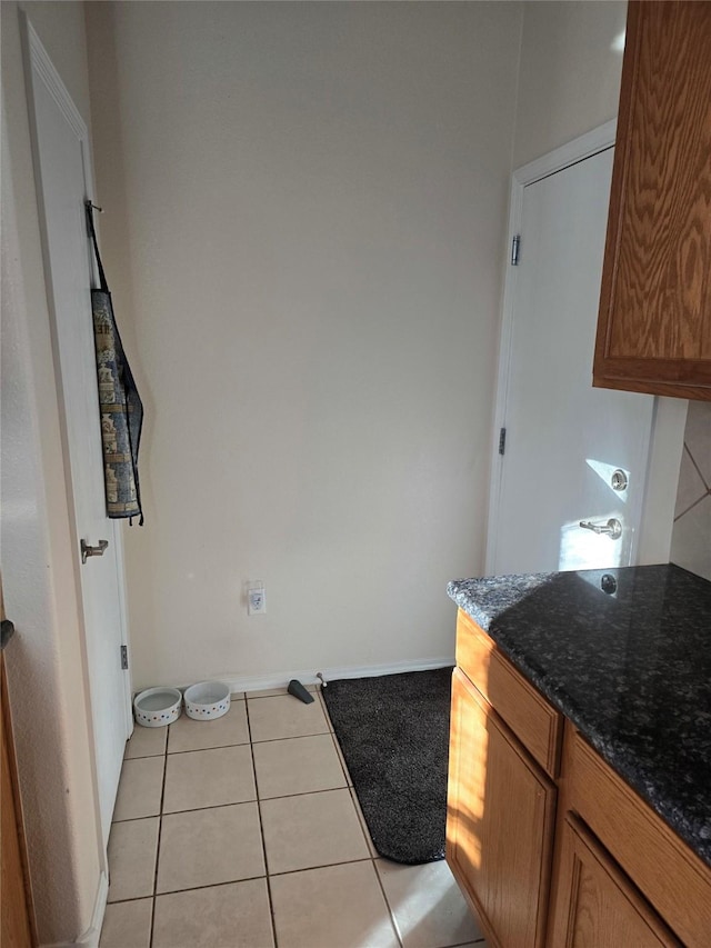 interior space featuring dark stone countertops and light tile patterned floors