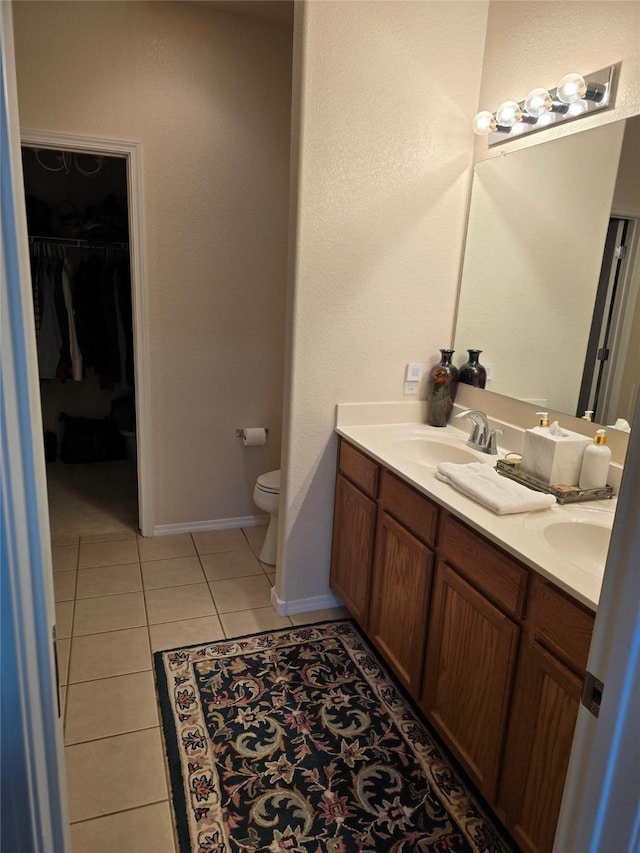 bathroom with tile patterned flooring, vanity, and toilet