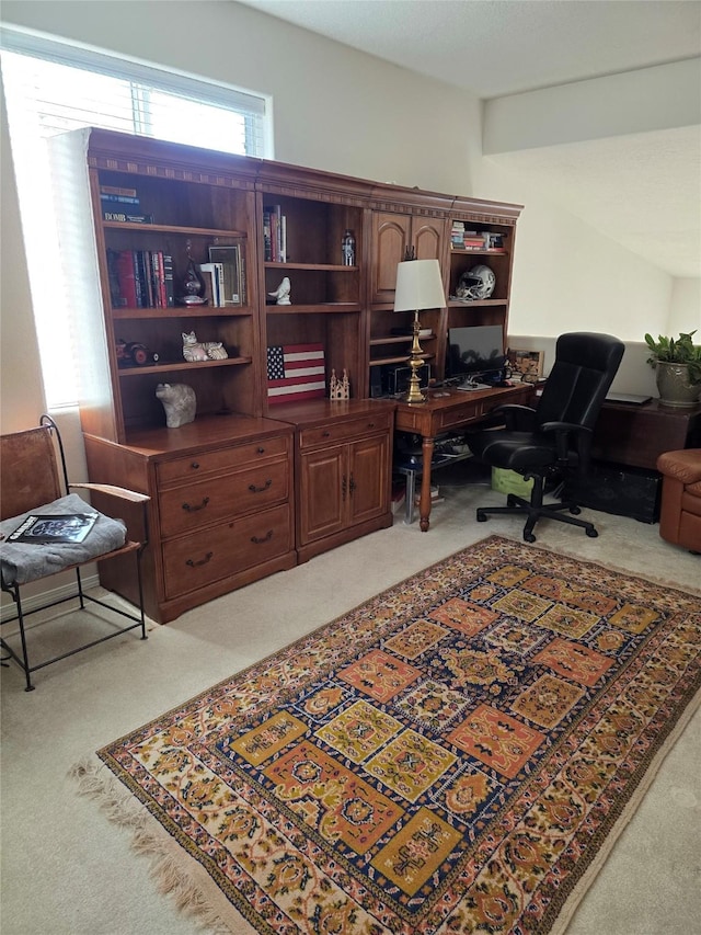 home office featuring light carpet and beamed ceiling