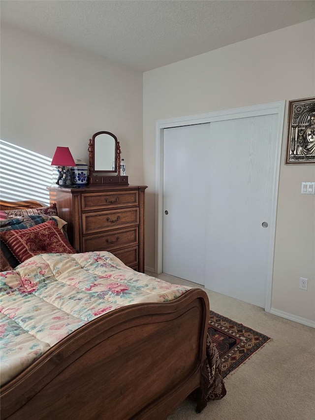 bedroom with a closet, carpet floors, and a textured ceiling