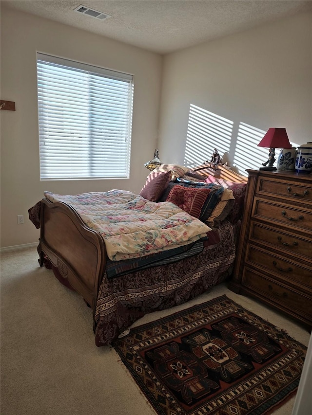 carpeted bedroom featuring a textured ceiling