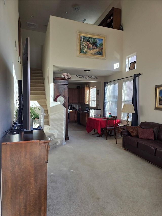 carpeted living room with a high ceiling