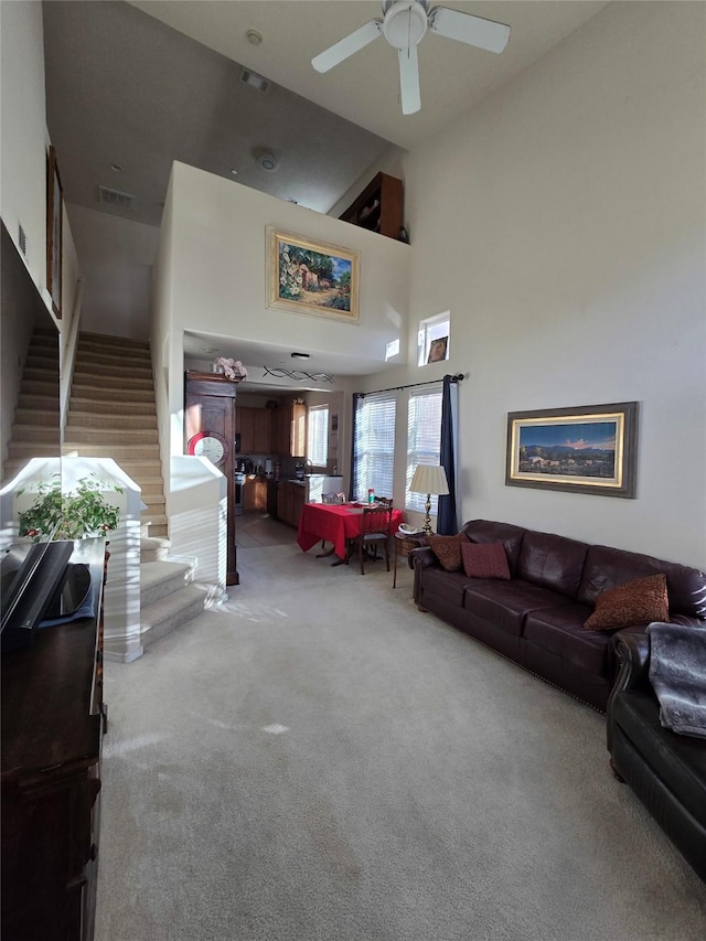 carpeted living room featuring high vaulted ceiling and ceiling fan