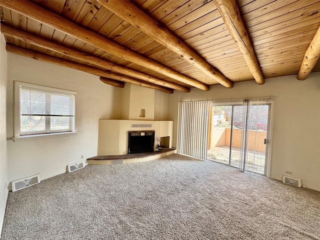 unfurnished living room with beam ceiling, carpet flooring, and wooden ceiling