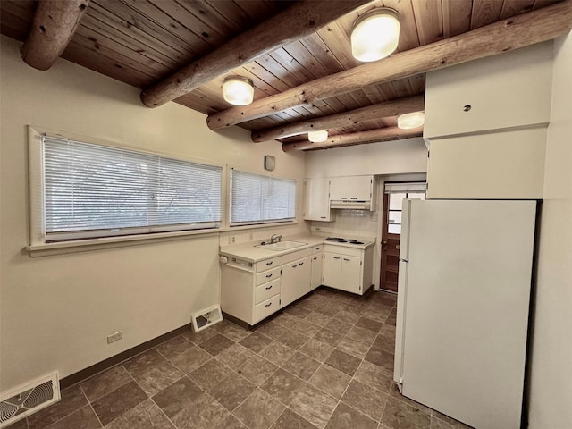 kitchen featuring tasteful backsplash, sink, white appliances, white cabinetry, and plenty of natural light