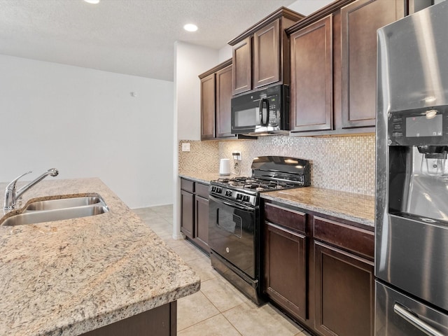 kitchen featuring decorative backsplash, sink, dark brown cabinetry, and black appliances