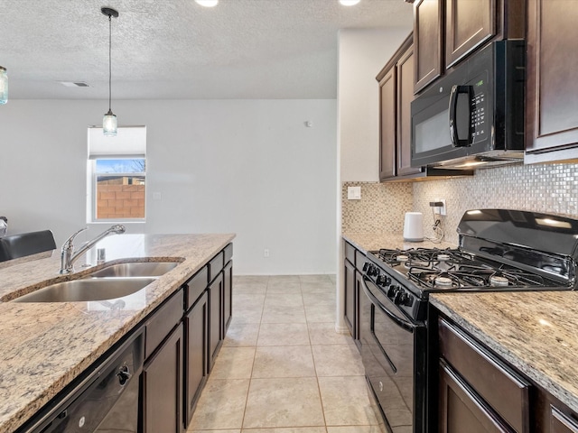 kitchen featuring hanging light fixtures, light stone countertops, sink, and black appliances