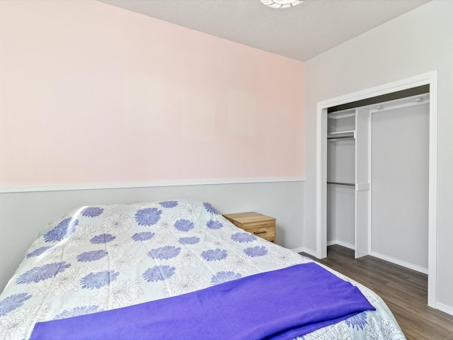 bedroom with dark hardwood / wood-style flooring and a closet