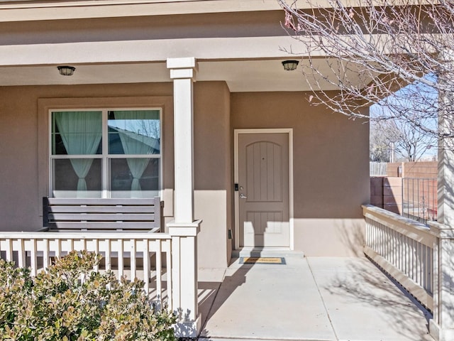 view of exterior entry featuring covered porch