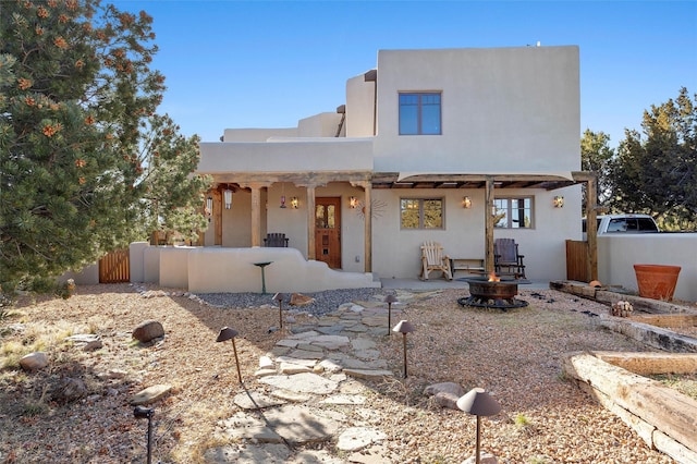 pueblo-style home featuring a fire pit