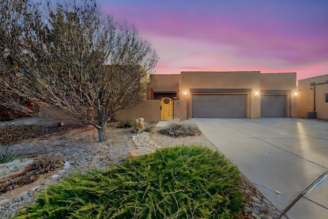 pueblo revival-style home featuring a garage