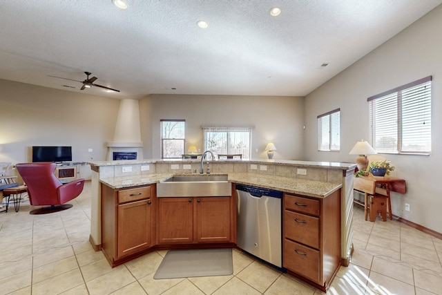 kitchen featuring stainless steel dishwasher, an island with sink, ceiling fan, and sink