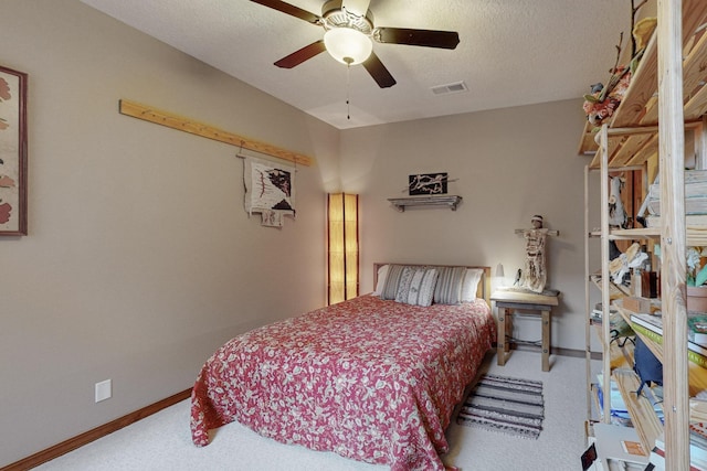 bedroom with ceiling fan, carpet, and a textured ceiling