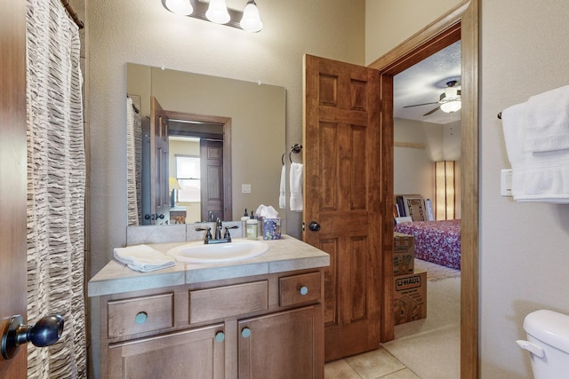 bathroom featuring ceiling fan, toilet, vanity, and tile patterned flooring