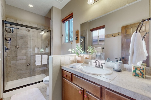 bathroom with toilet, tile patterned flooring, an enclosed shower, and vanity