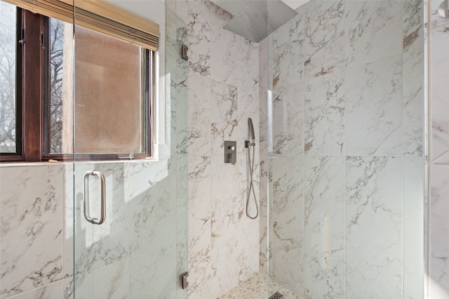 bathroom with a shower with door and a healthy amount of sunlight