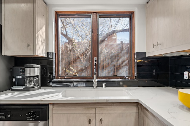 kitchen with decorative backsplash, dishwashing machine, light brown cabinetry, and light stone counters